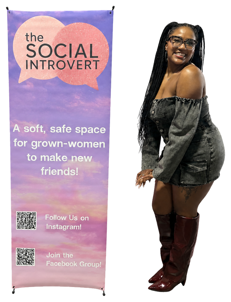 Founder Ciya Hawkins standing beside The Social Introvert sign